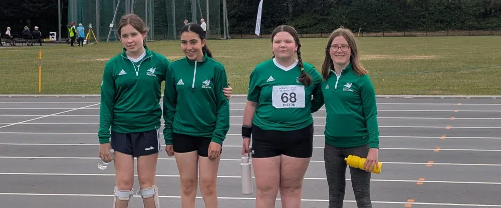 junior para athletes posing in a group in front of a running track