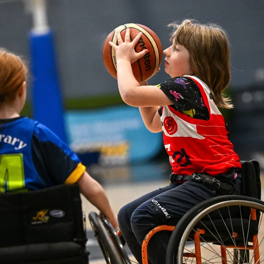 female junior wheelchair basketball player about to throw a basketball