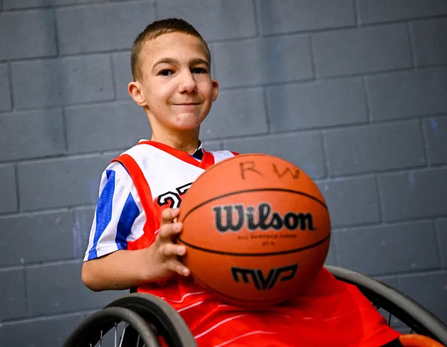 junior wheelchair basketball player holding basketball